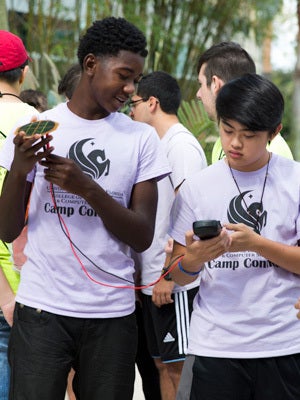 two highschool students wearing ucf shirts working together on science project